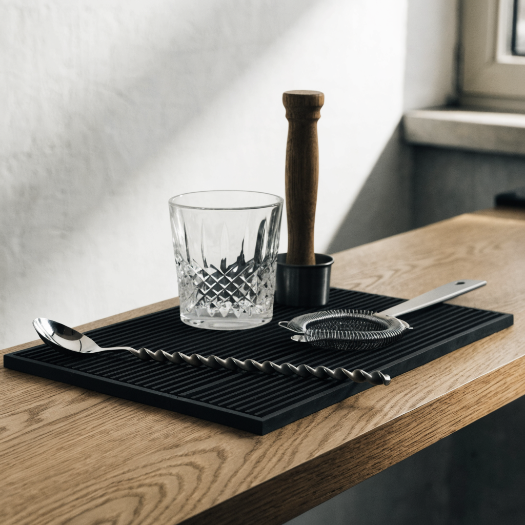 Barlepel met mengglas en muddler opgeruimd op een barmat - Glazen.nl
