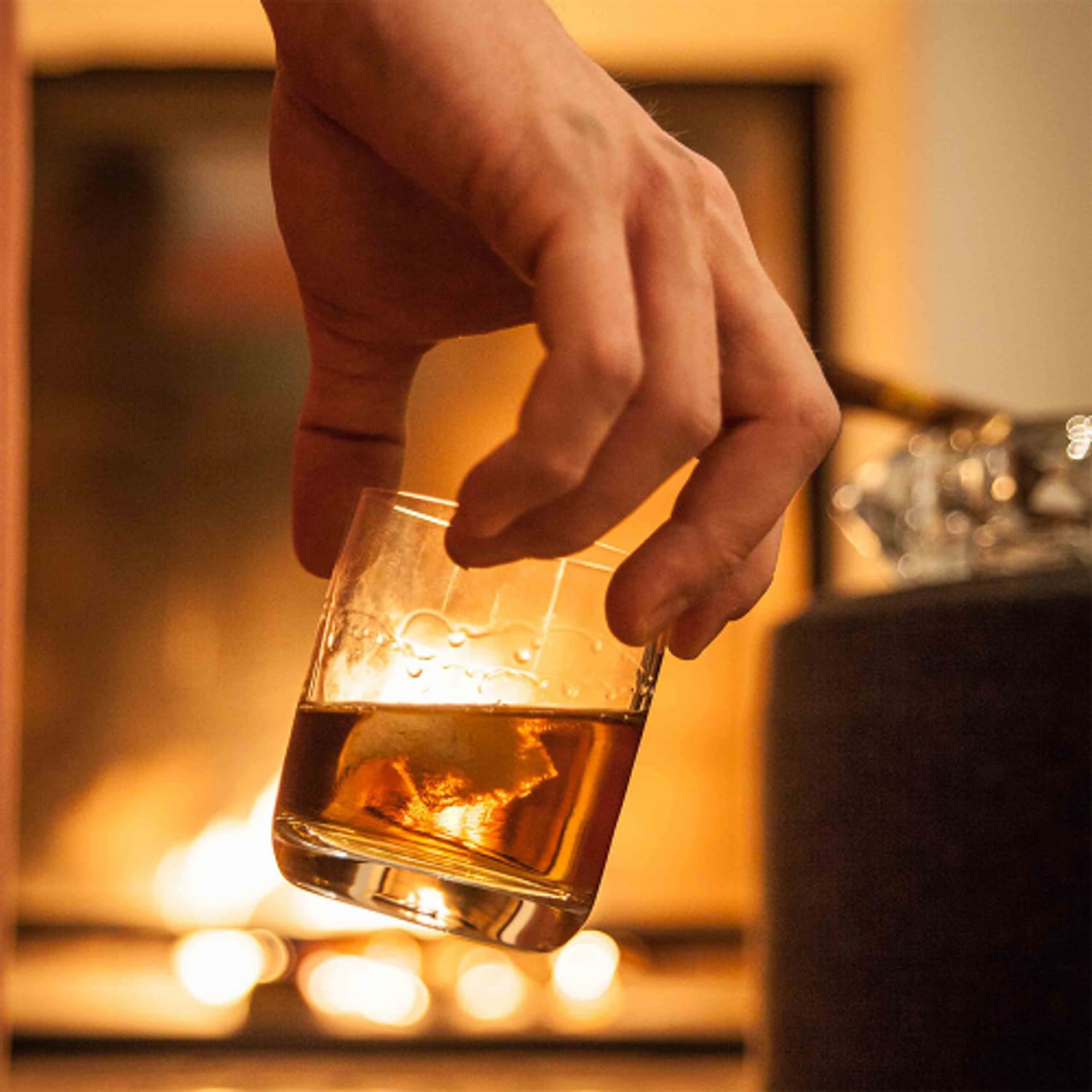 Stölzle Lausitz Classic tumbler met whisky bij de open haard, sfeerbeeld