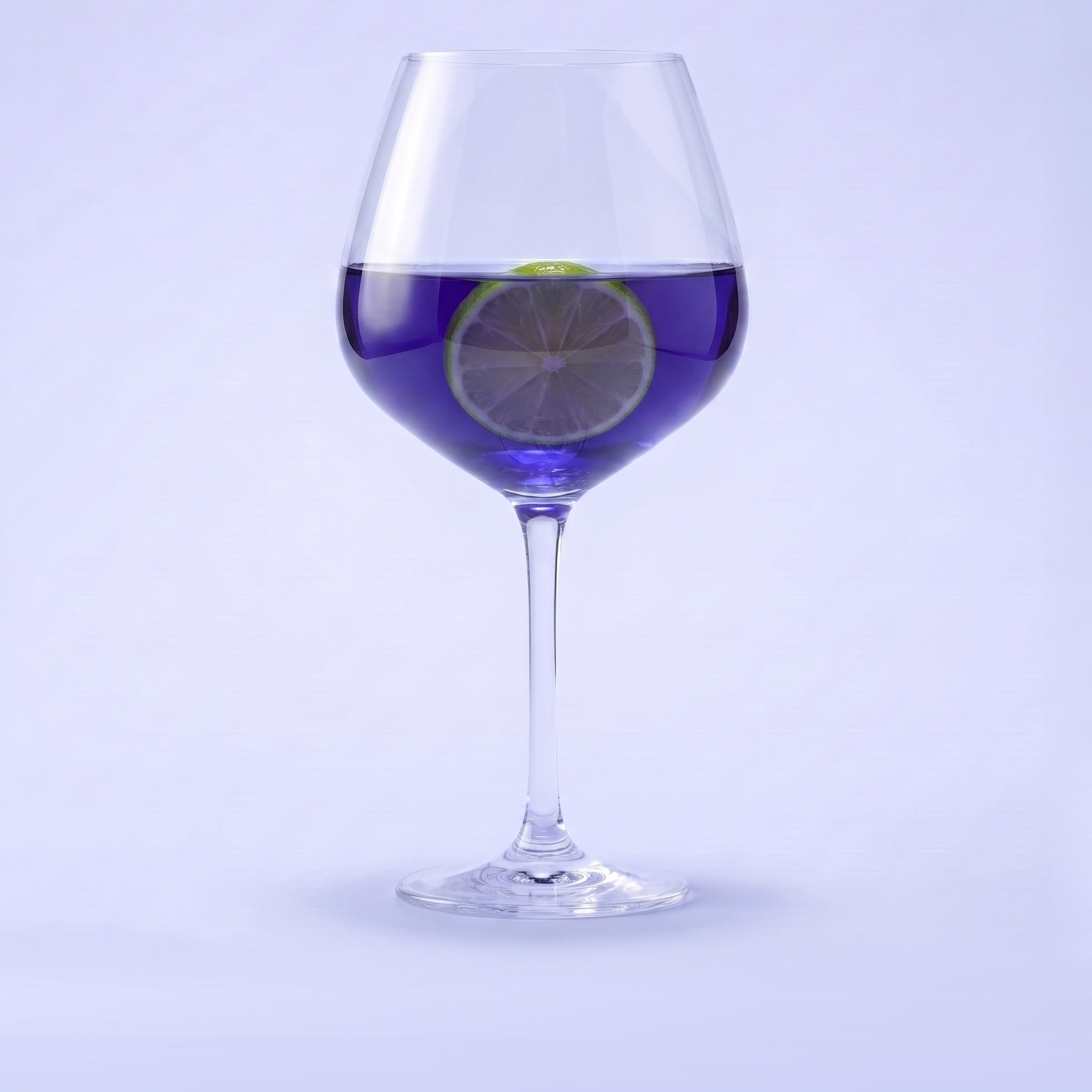 Royal Leerdam Enjoy The Moment gin tonic glas 75 cl gevuld met violetblauwe gin-tonic en limoen op pastelblauwe studioachtergrond